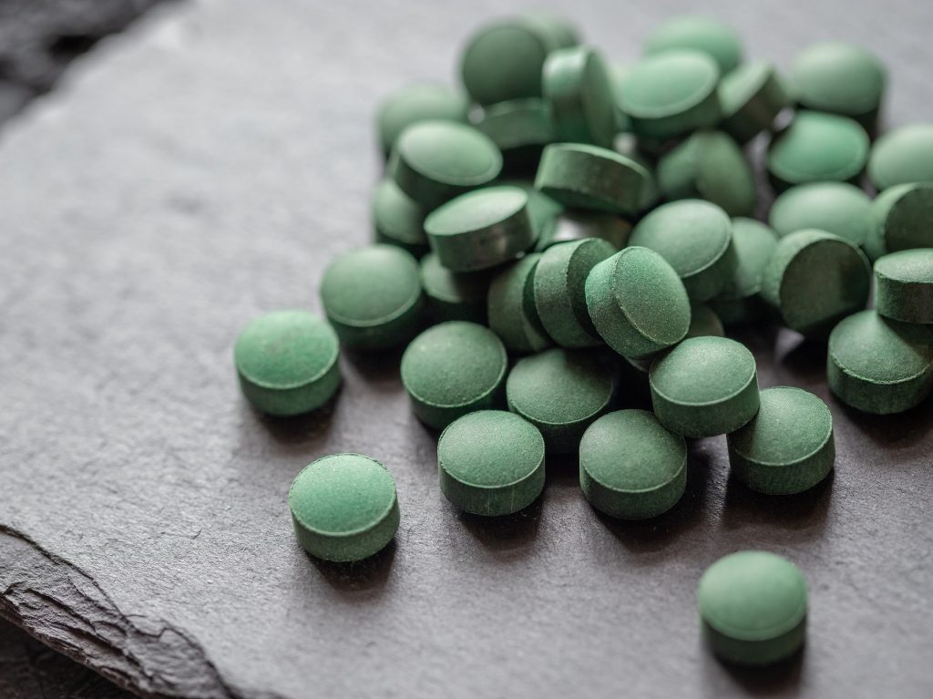 Spirulina-Tabletten auf einer Steinplatten.