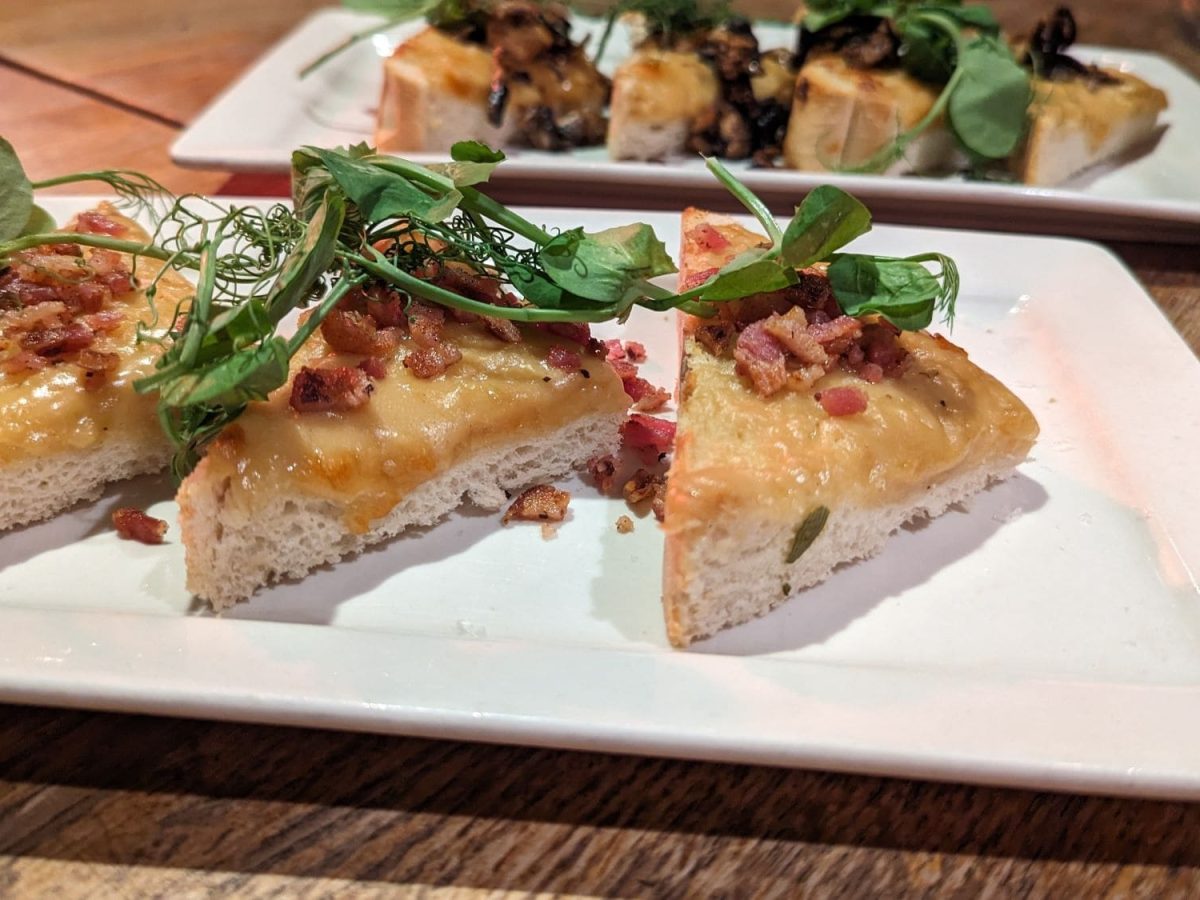 Mehrere Scheiben Welsh Rarebit auf weißen Tellern.