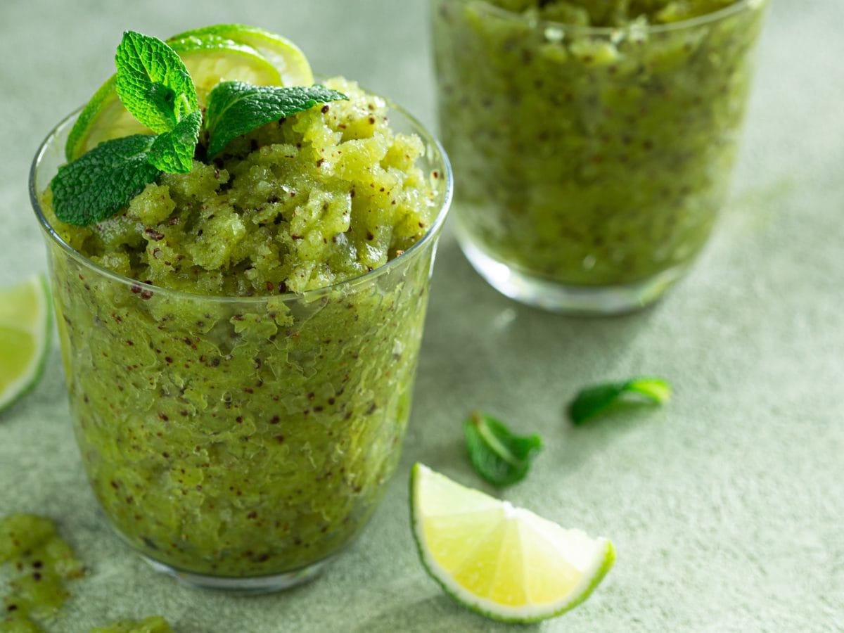 Zwei Gläser mit dem Granita auf einem hellgrünen Tisch. Alles von schräg oben fotografiert.