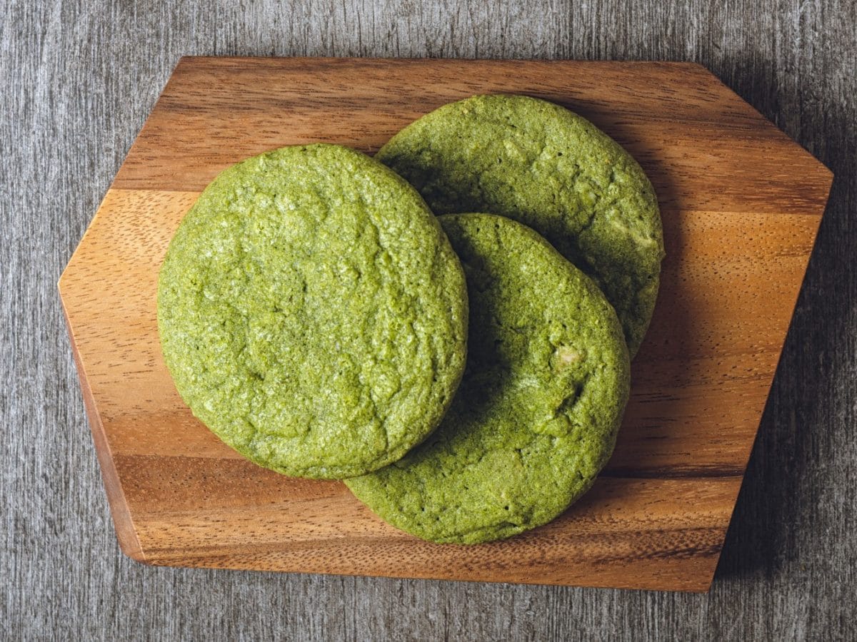 Matcha-Cookies auf einem hölzernen Brett. Der Hintergrund ist grau.