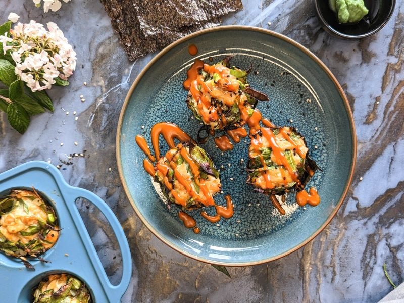 Die Sushi-Muffins von auf blauem Teller und grauem Marmortisch. Alles direkt von oben fotografiert.