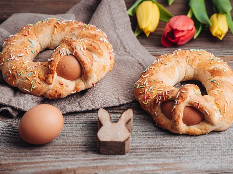 Scarcelle pugliesi auf einem grauen Tuch. Davor ein braunes Ei und ein Holzosterhase. Im Hintergrund Tulpen.