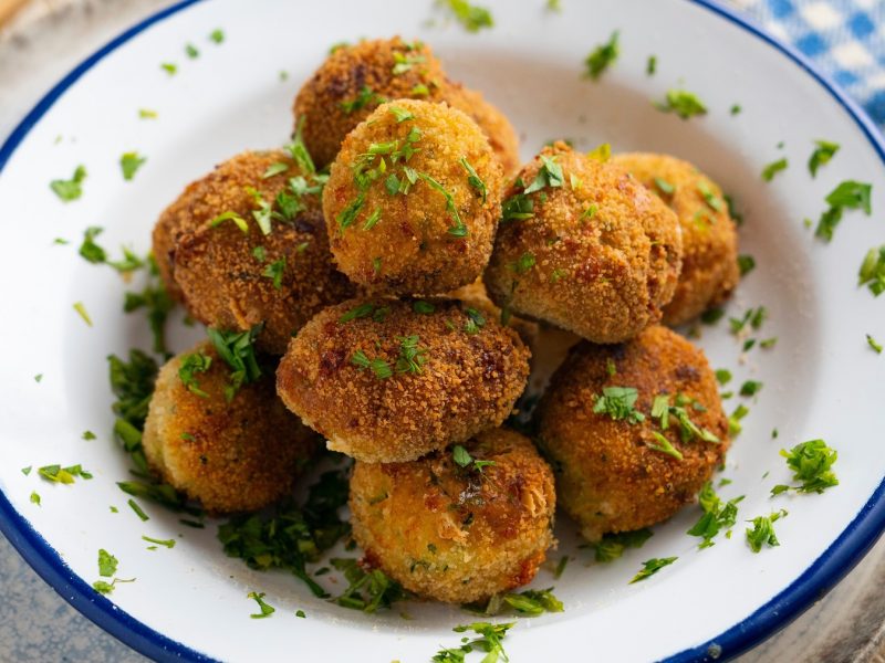 Brokkoli-Kroketten auf einem weißen Teller mit Petersilie.