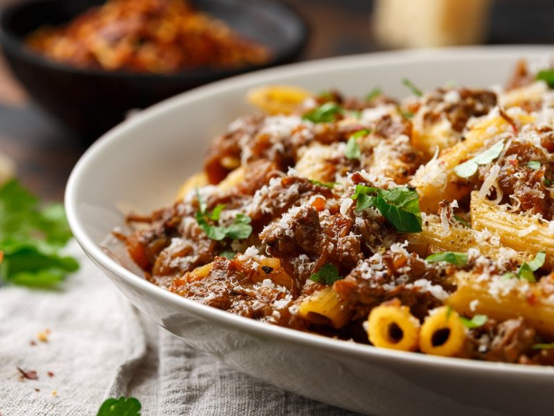 Pasta alla genovese auf einem weißen Teller mit Parmesan und Petersilie. Als Nahaufnahme fotografiert.