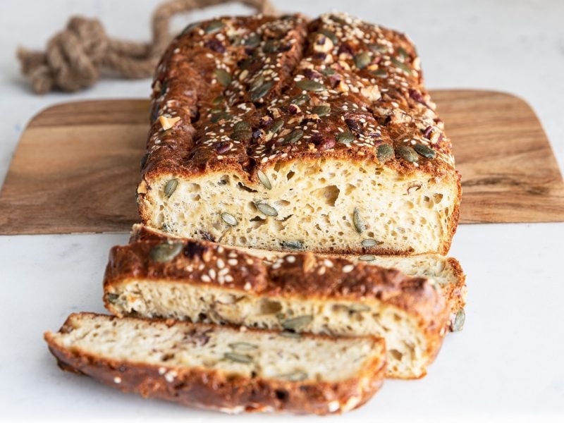 Angeschnittenes Tahini-Brot von vorne fotografiert auf einem Holzbrett.