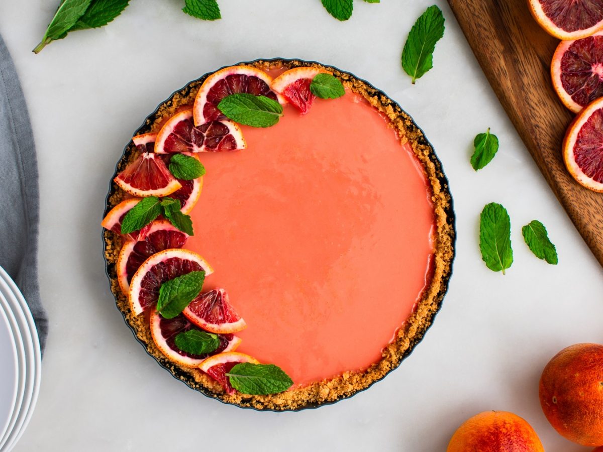 Draufsicht von Aperol Spritz Tarte dekoriert mit Blutorangen.