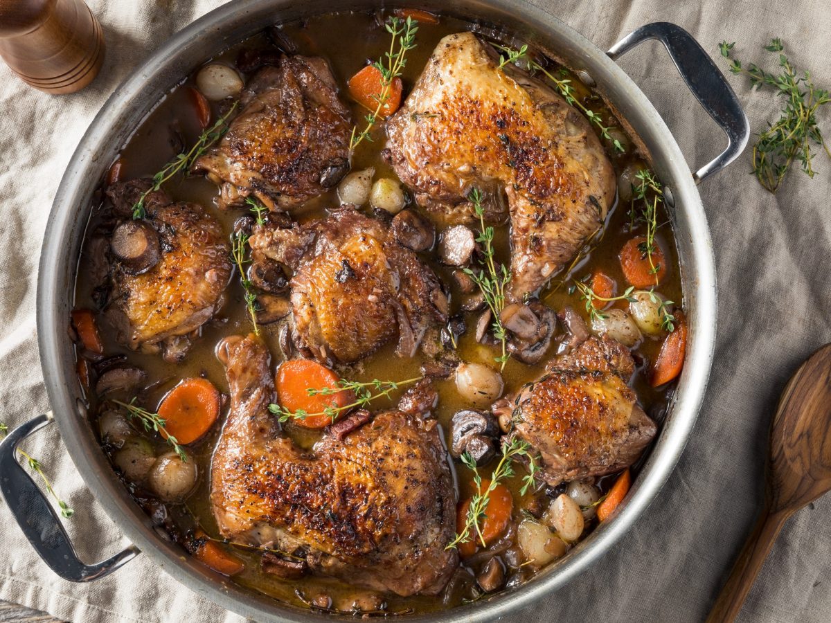 Draufsicht: Ein Schmortopf mit Coq au Vin de Bourgogne.