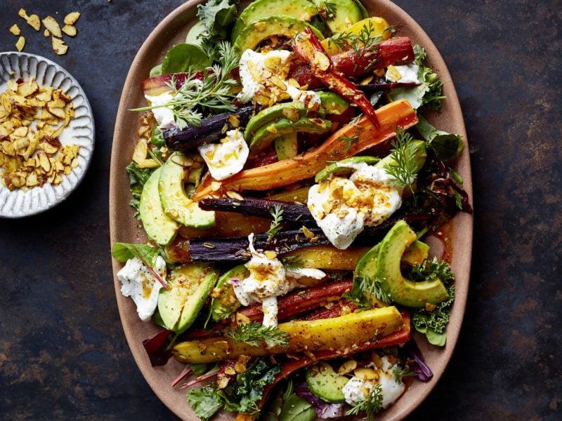 Draufsicht: Indian-Summer-Röstmöhren mit Avocado und Burrata angerichtet auf einem großen Teller