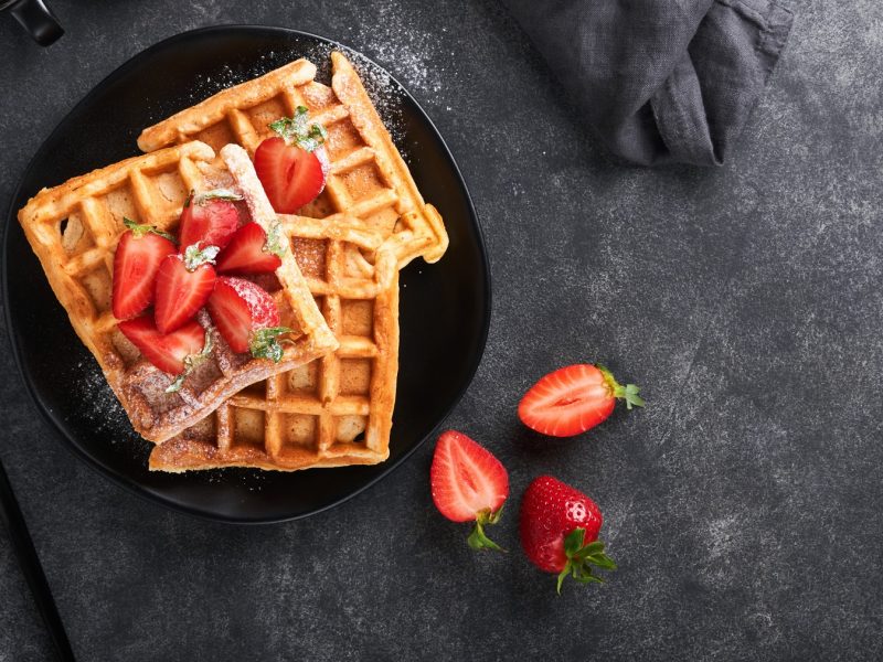 Zuckerfreie Waffeln, mit Puderzucker und Erdbeeren garniert.