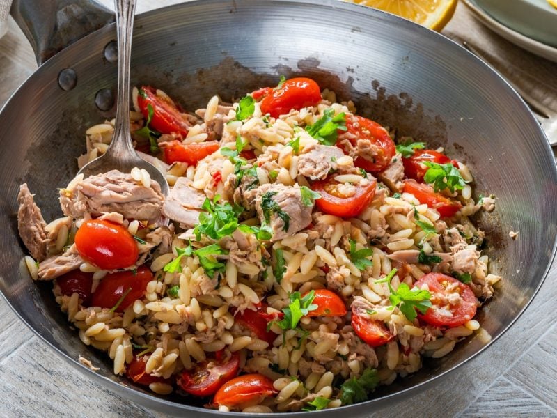 Draufsicht, leicht schräg: eine gusseiserne Pfanne mit einer Orzo-Thunfisch-Pasta.