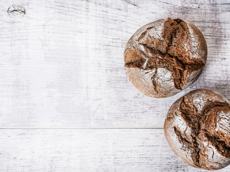 Draufsicht. Zwei Schnelle Roggenbrötchen ohne Sauerteig auf einem mattiertem, weißen Untergund.