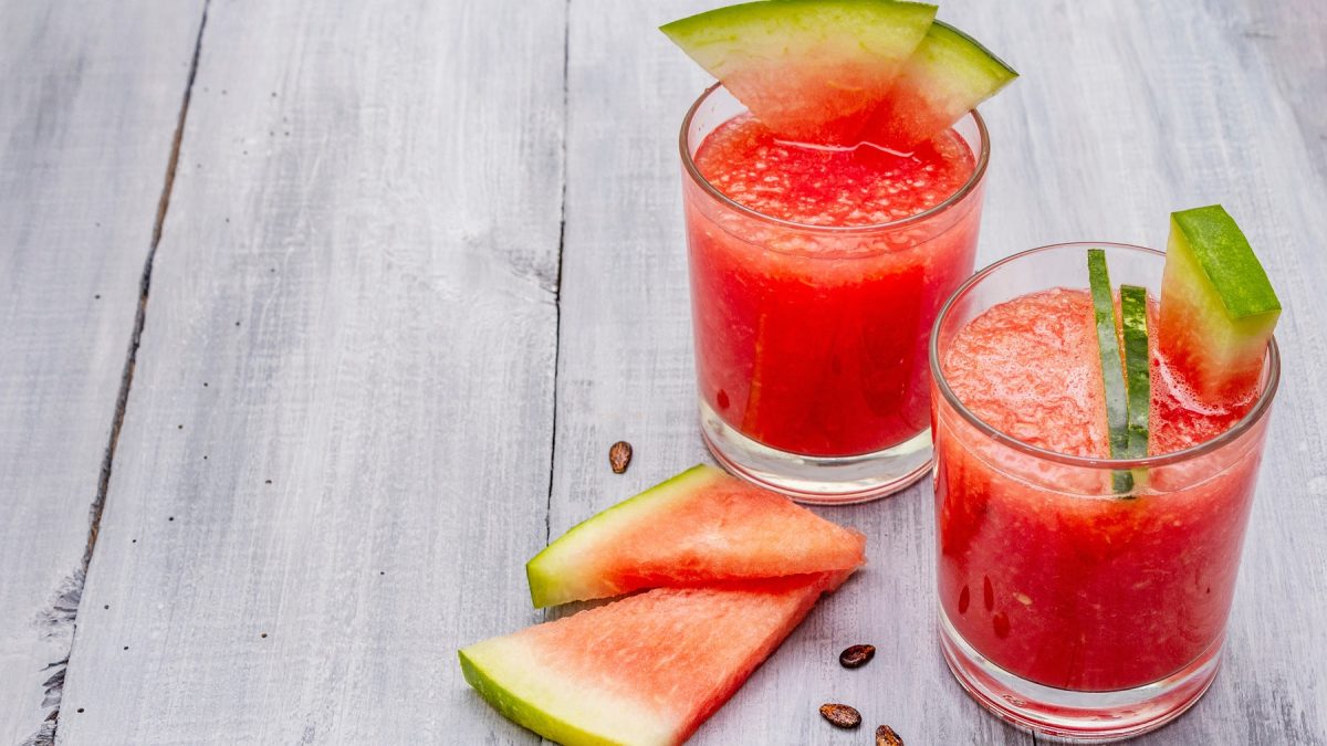 Zwei Shot-Gläser mit Wassermelonen-Mexikaner auf einem grauen Tisch von schräg oben fotografiert.