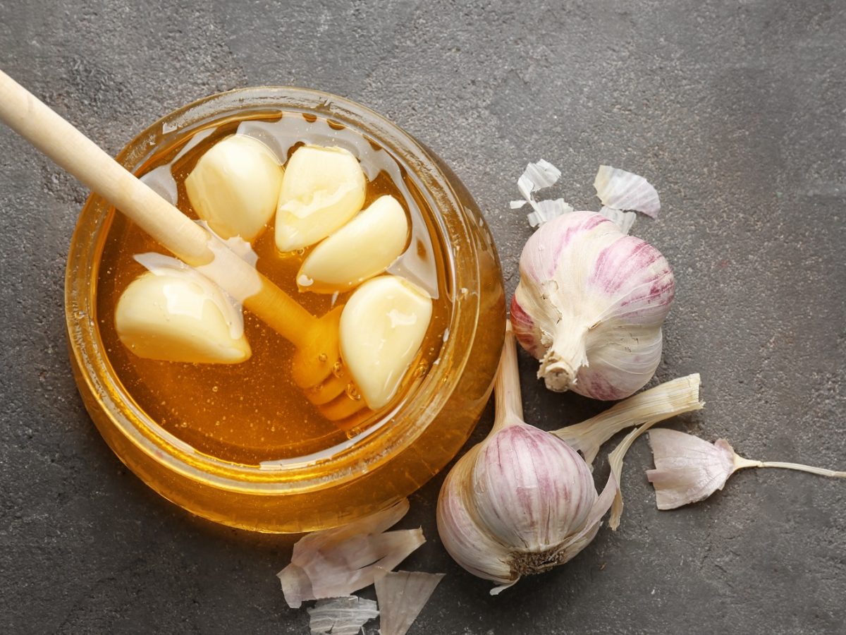 Knoblauch in Honig fermentiert in einem Glas von oben fotografiert.