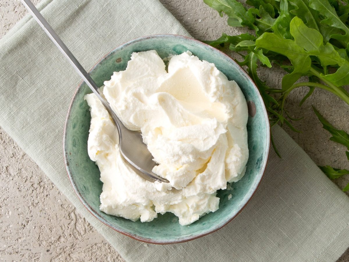 Selbstgemachte Mascarpone in einer blauen Schüssel von oben fotografiert.