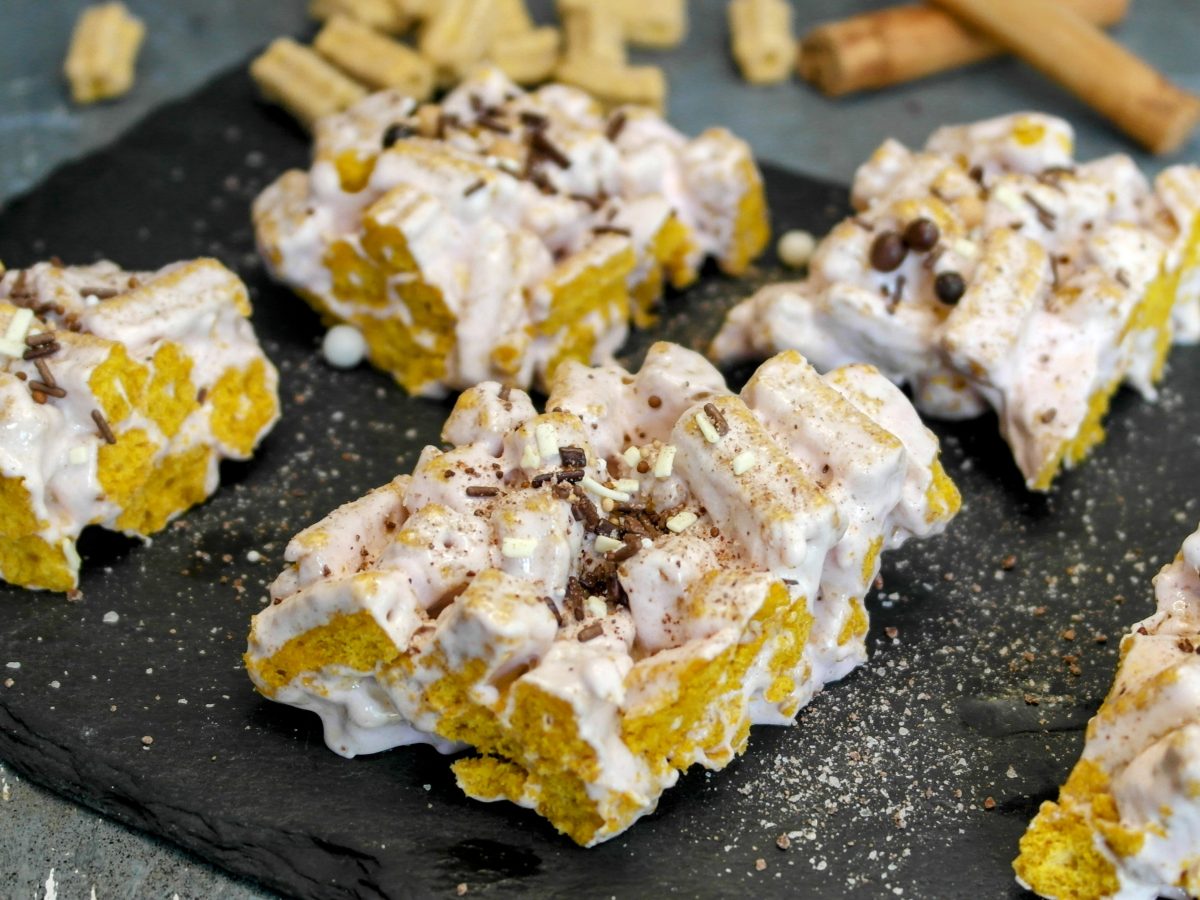 Mehre Portionen der Sticky-Cereals auf einer schwarzen Schieferplatte und grauem Steintisch. Alles von schräg oben fotografiert.