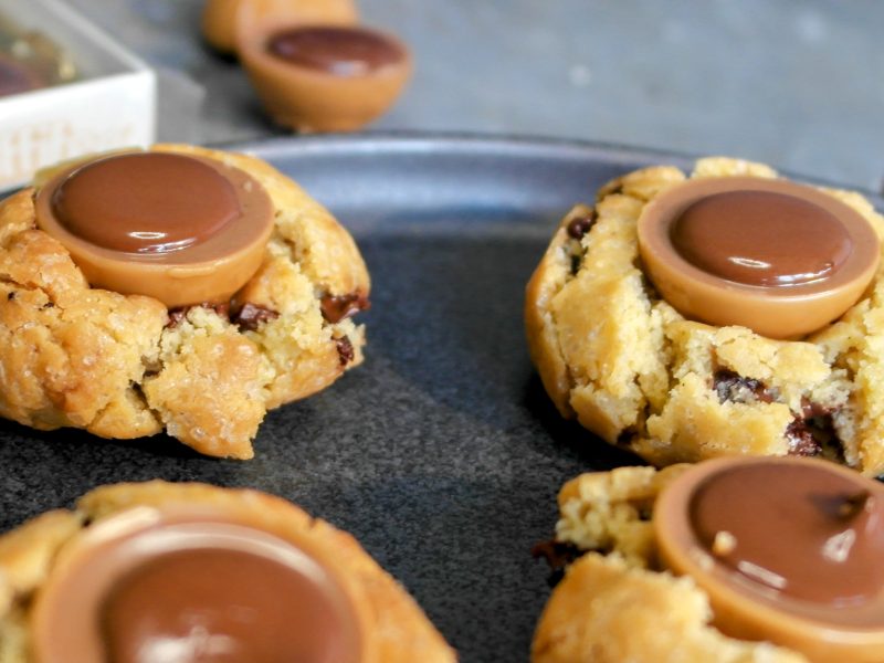 Die Toffifee-Cookies auf einem dunklen Teller in der Nahansicht, mit einer Packung Toffifee im Hintergrund.