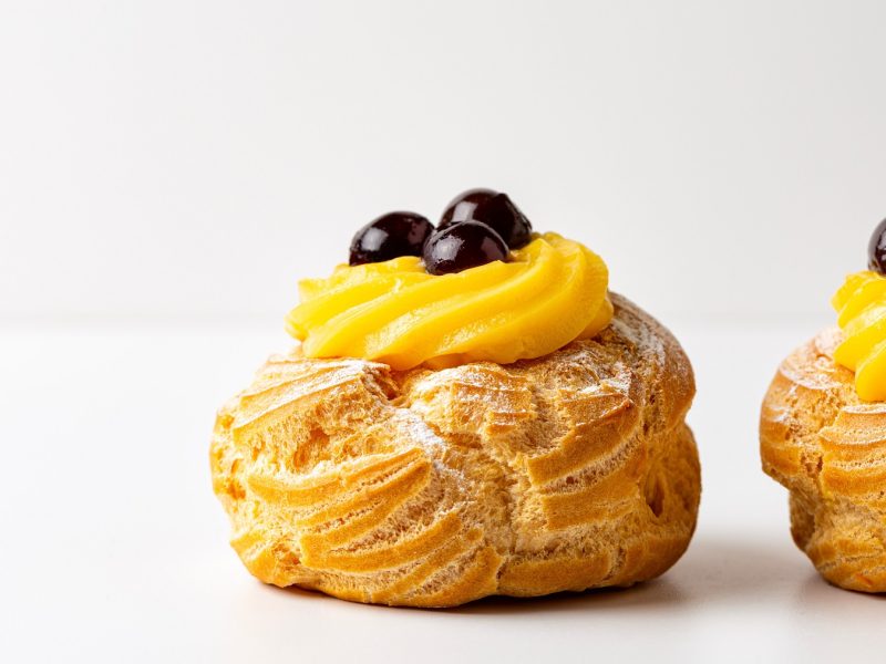 Zeppola di San Giuseppe als Nahaufnahme vor weißem Hintergrund.