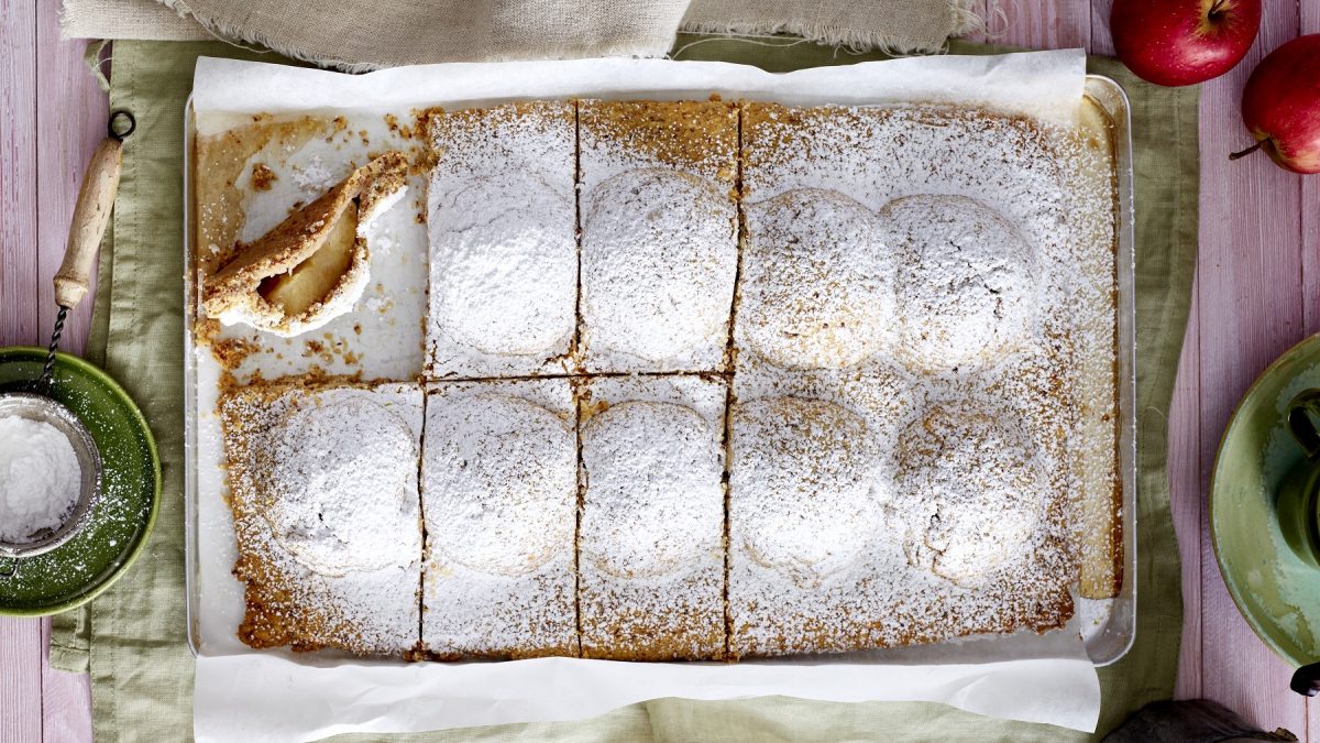 Apfelkuchen im Knuspermantel mit Puderzuckerdecke von oben fotografiert.