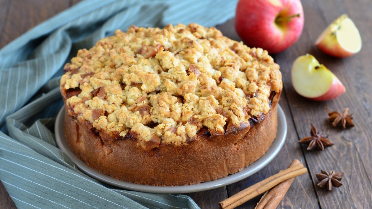 Apfeltorte von vorne fotografiert, daneben Zimtstange, Anissterne und Äpfel.