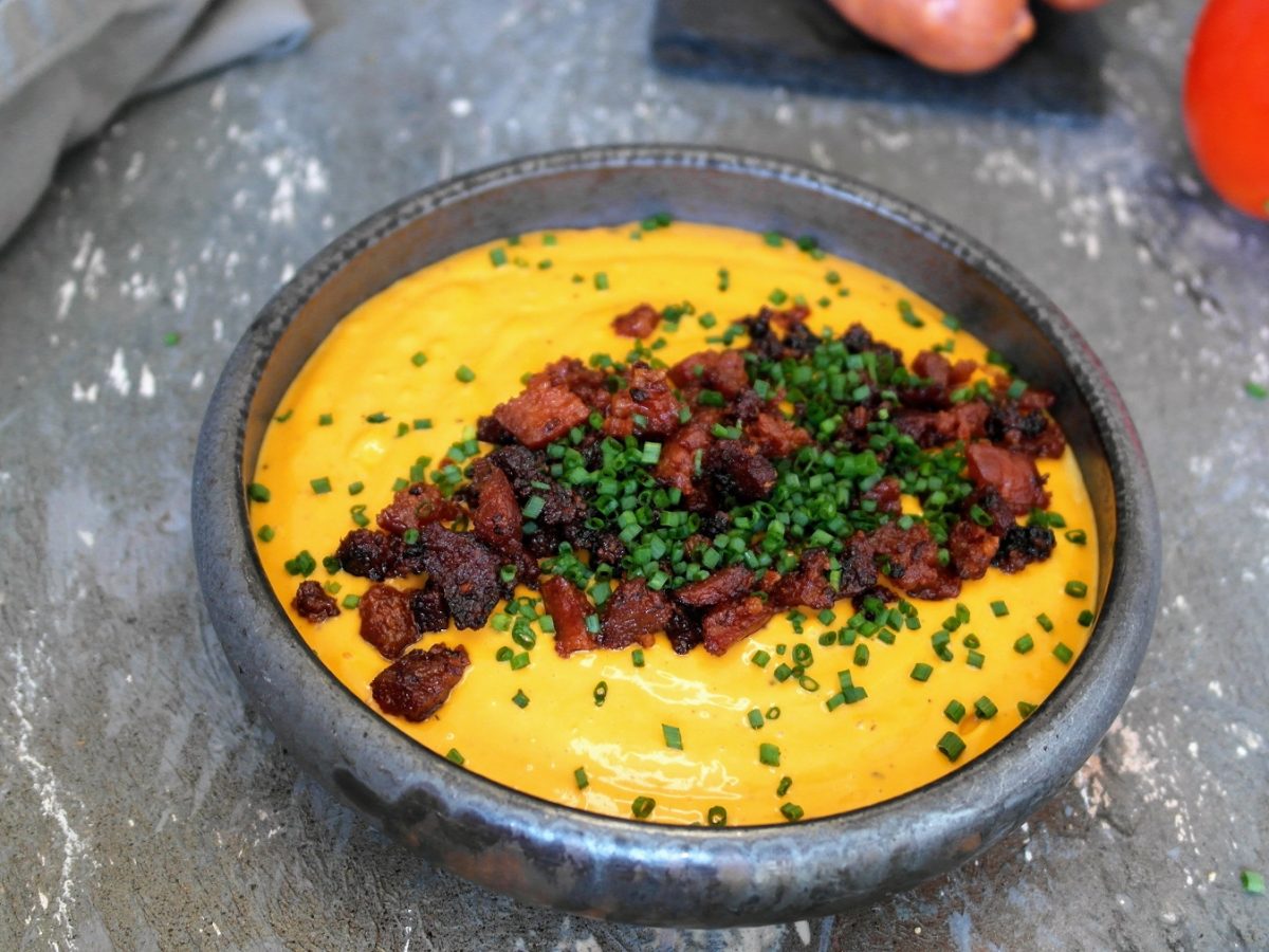 Eine graue Schale mit der Chorizo-Mayonnaise auf einem grauen Steintisch. Alles von schräg oben fotografiert.