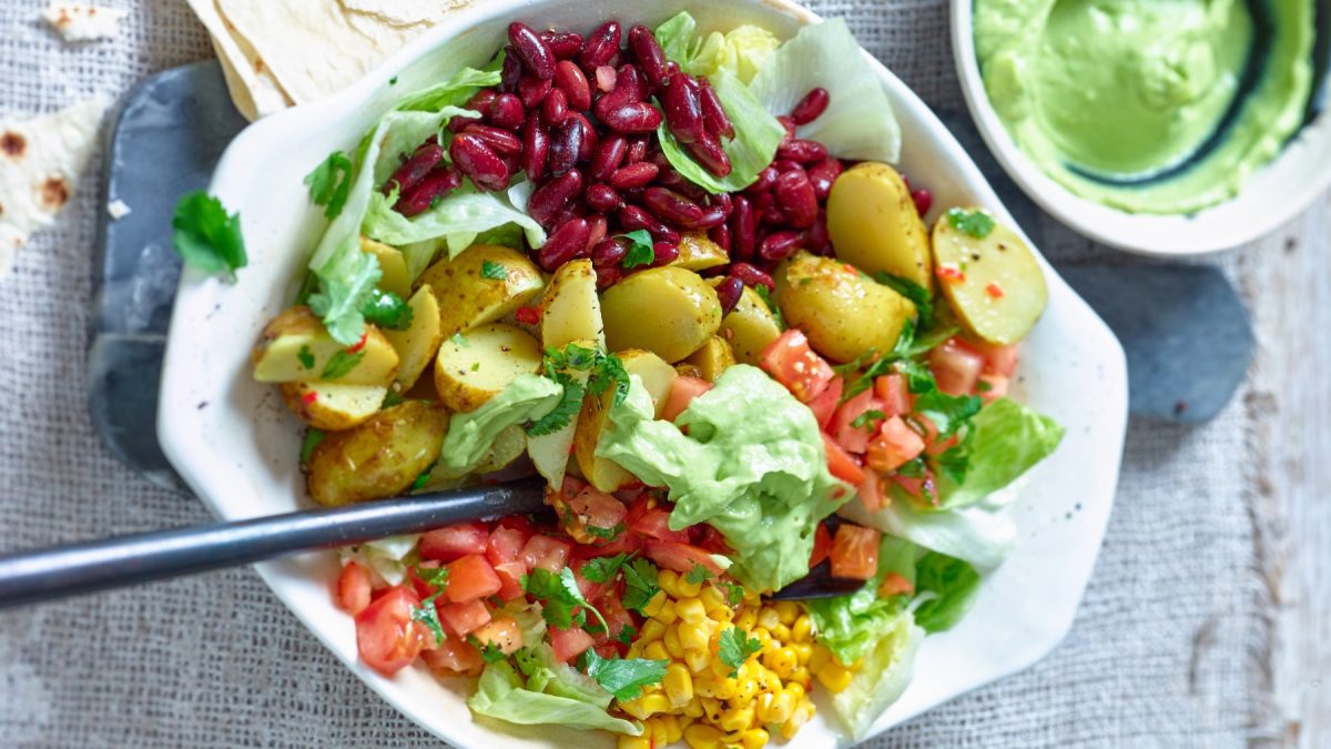 Draufsicht: Mexikanischer Kartoffelsalat in weißer Schüssel auf grauem Untergrund.