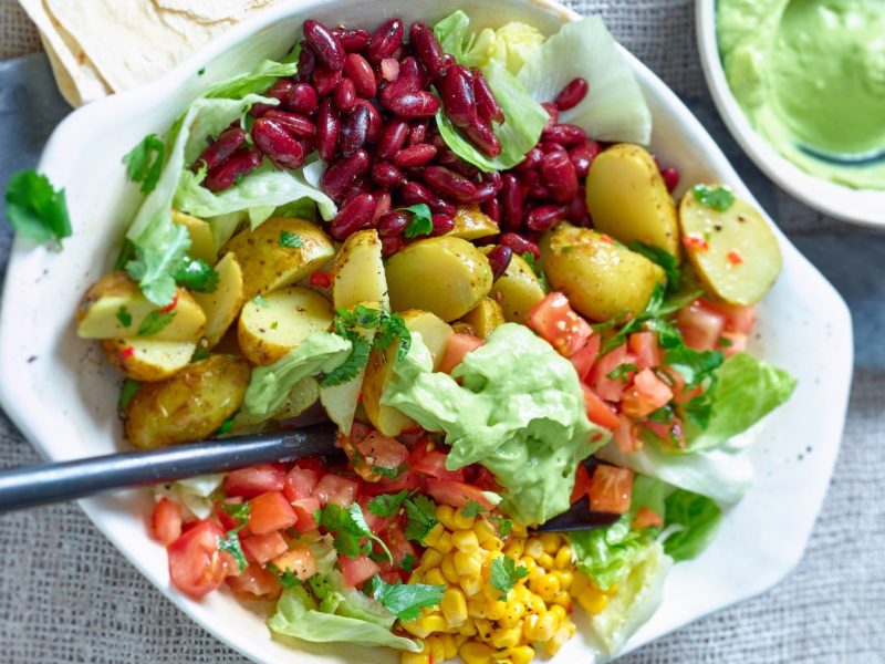 Draufsicht: Mexikanischer Kartoffelsalat in weißer Schüssel auf grauem Untergrund.