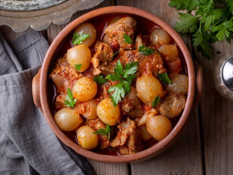 Griechischer Stifado mit Rindfleisch und Perlzwiebeln von oben fotografiert.