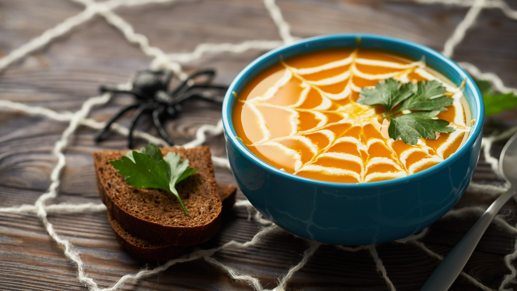 Halloween-Kürbissuppe auf hölzernem Hintergrund.