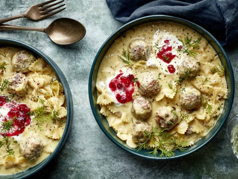 Draufsicht: Zwei tiefe Teller mit One-Pot-Pasta Köttbullarstyle auf grauem Untergrund.