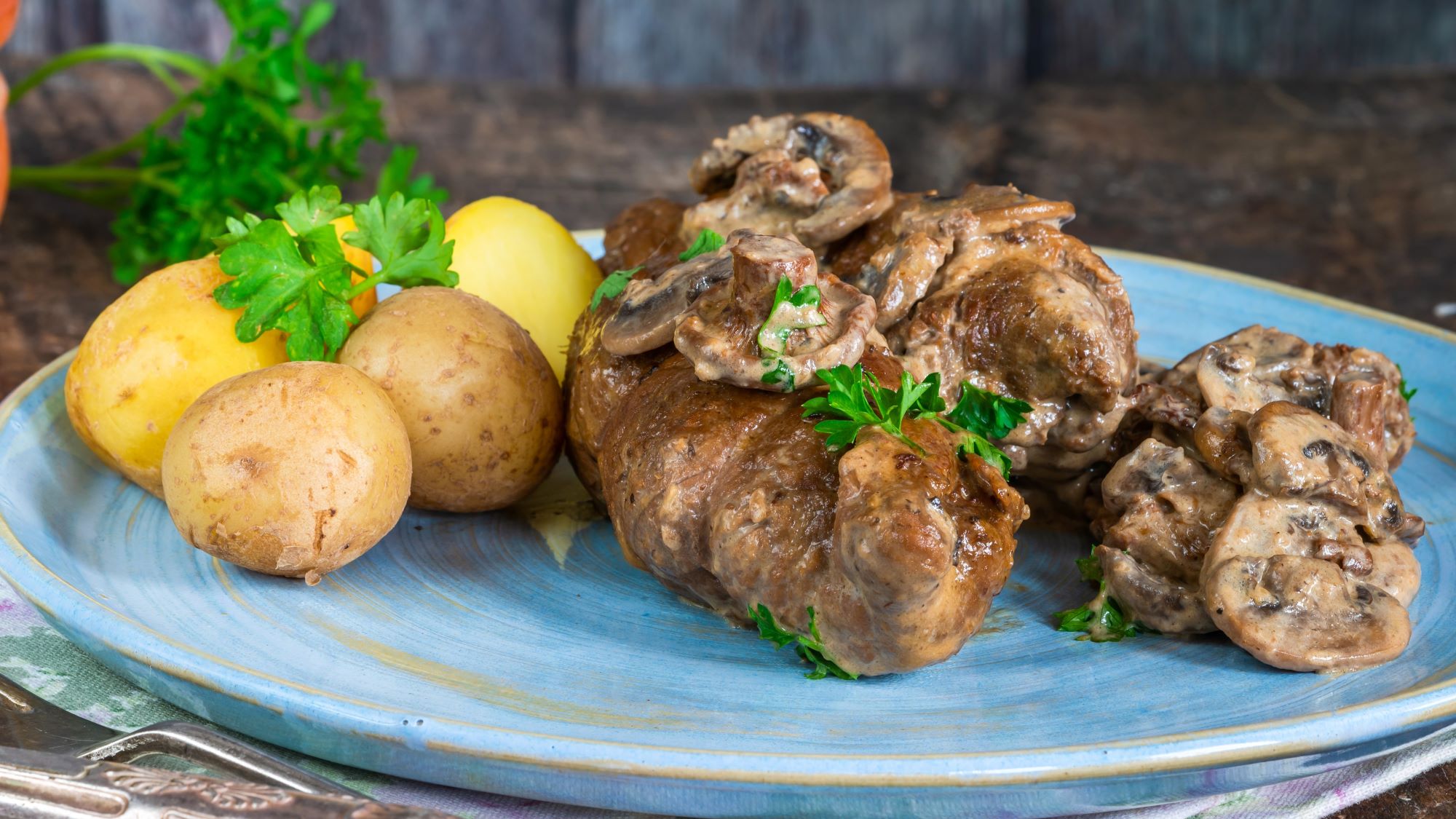 Kroatisches Schnitzel Baron Trenk auf einem blauen Teller serviert.