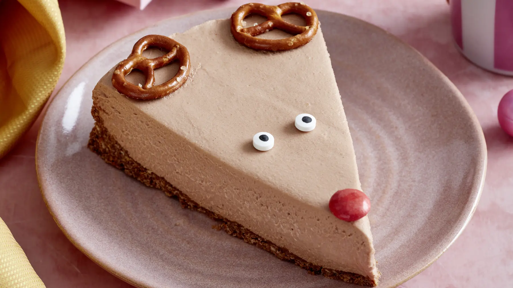 Rudolph-Cheesecake auf einem rosa Teller auf rosa Hintergrund.