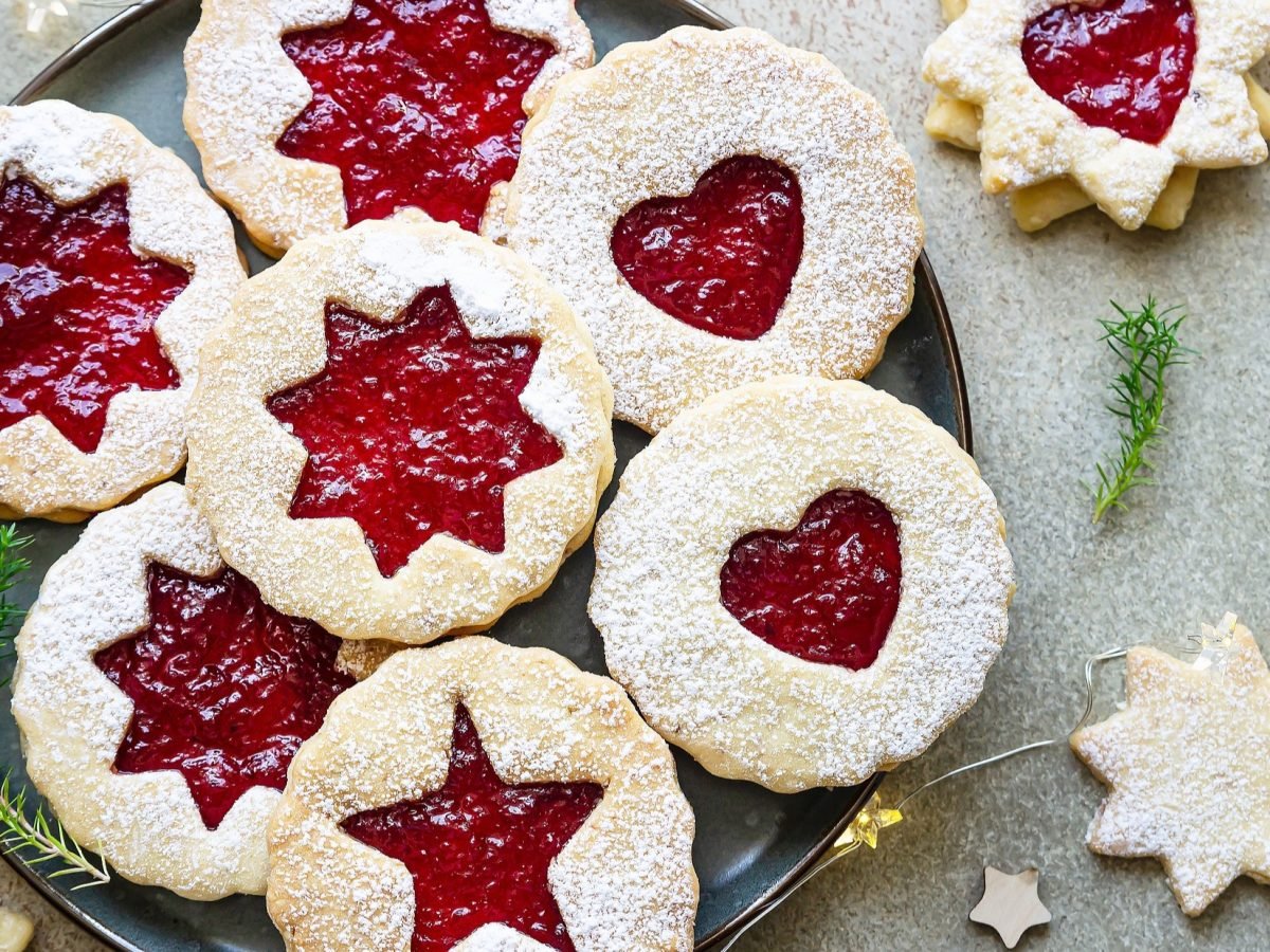 Draufsicht: Das Weihnachtsgebäck Spitzbuben liegt auf einem hellen Untergrund. Es sind 8 Spitzbuben.