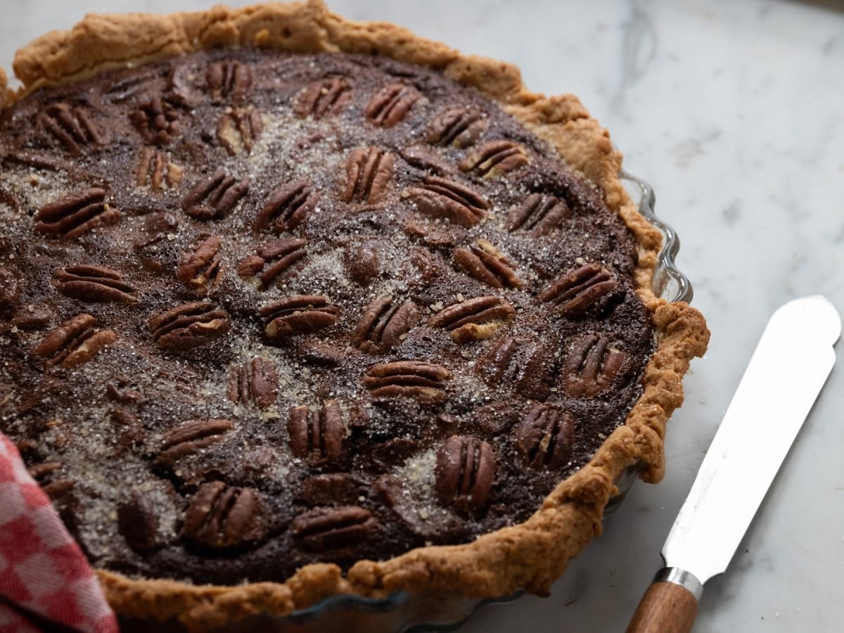 Der Pekanusskuchen auf einem Marmortisch von schräg oben fotografiert.