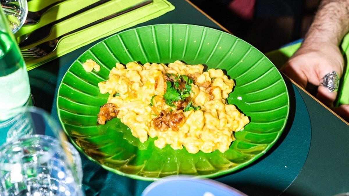 Pflanzliche Trüffel-Käsespätzle auf einem grünen Teller von schräg oben fotografiert.