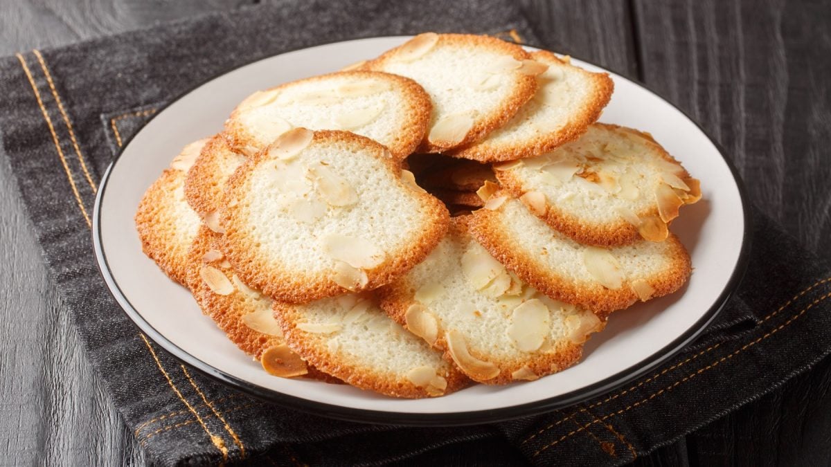 Tuiles aux amandes auf einem weißen Teller von schräg oben fotografiert.