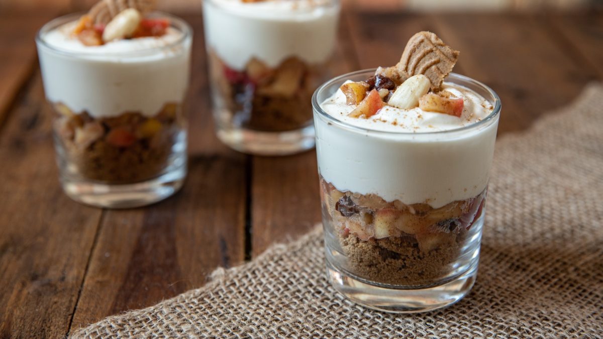 Veganes Bratapfel-Dessert in 3 Gläsern auf hölzernem Hintergrund.