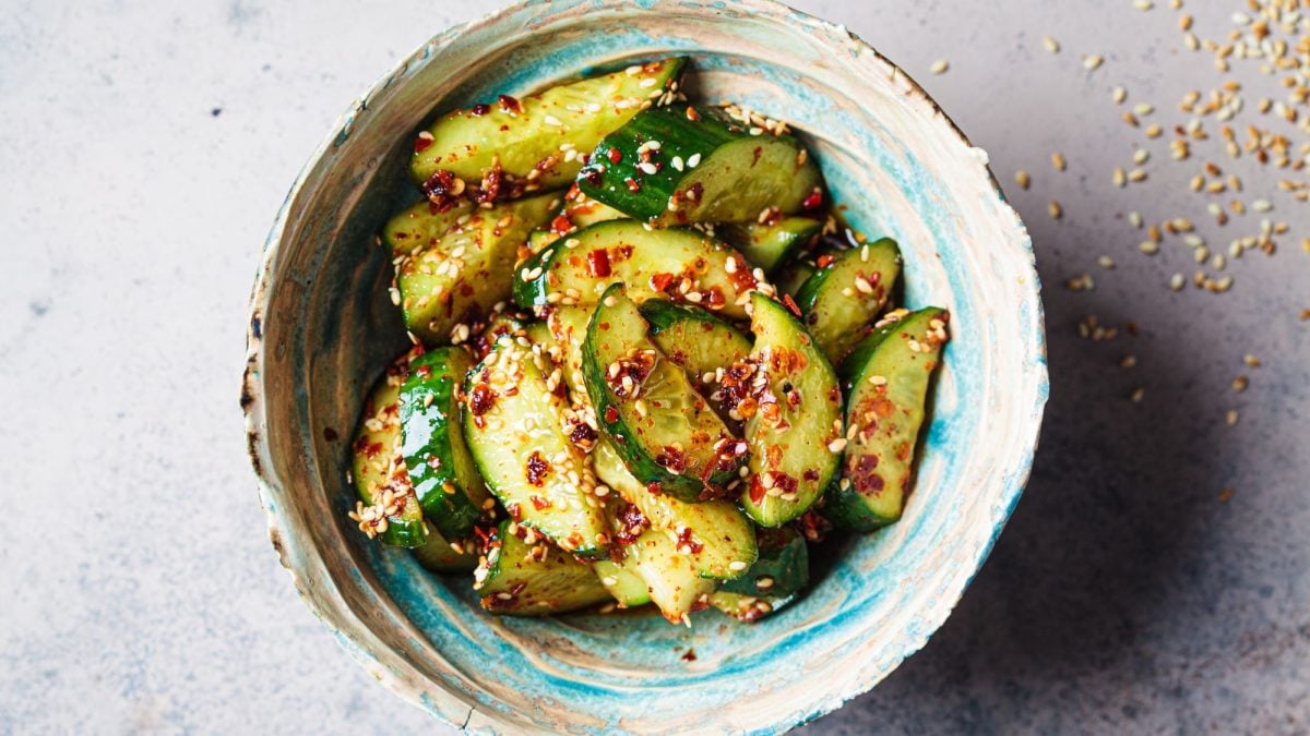 Eine kunstvoll verzierte Schale gefüllt mit einem japanischen Gurkensalat mit Sesam und Chili.