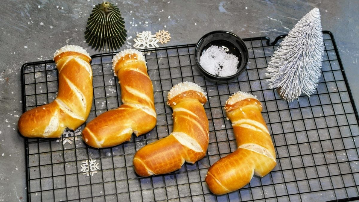 Die Laugen-Stiefel auf einem schwarzen Backgitter und grauem Steintisch mit weihnachtlicher Dekoration von schräg oben fotografiert.