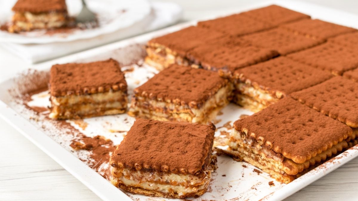 Der Brick Cake auf einem weißen Tablett und hellem Holztisch. Alles von der Seite fotografiert.